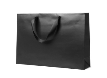 Paper shopping bag with ribbon handles on white background. Mockup for design