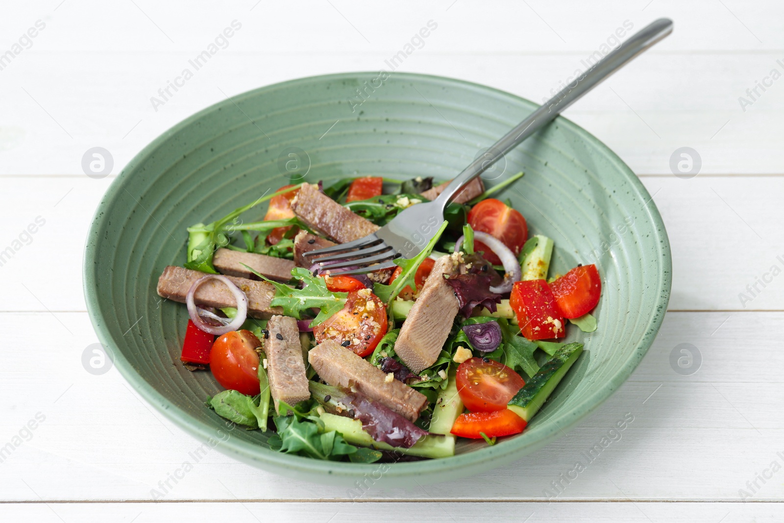 Photo of Delicious salad with beef tongue, vegetables and fork on white wooden table