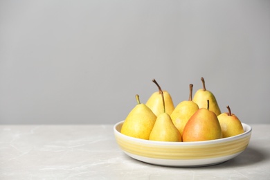 Plate with pears on table against grey background. Space for text