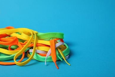 Photo of Colorful shoe laces on light blue background. Space for text