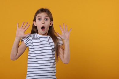 Photo of Portrait of surprised girl on yellow background. Space for text
