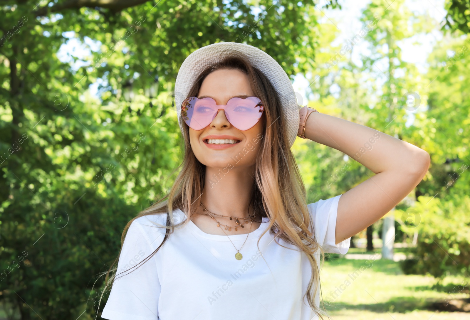 Photo of Portrait of happy woman with heart shaped glasses in summer park