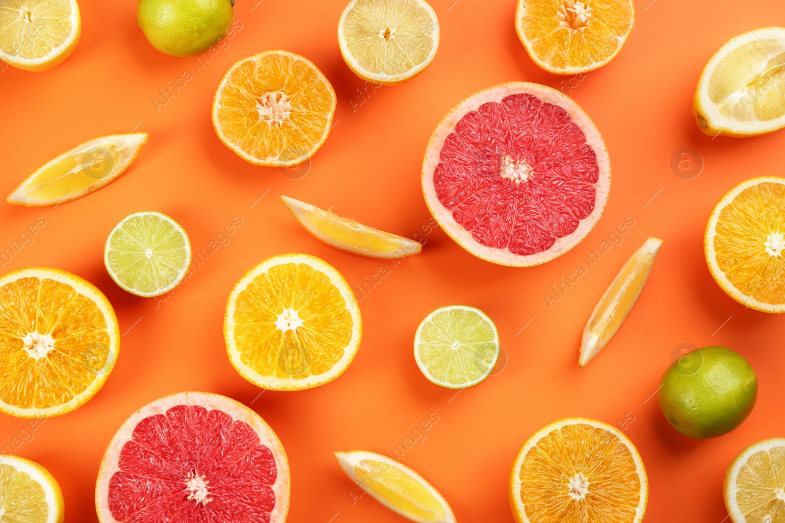 Photo of Flat lay composition with tangerines and different citrus fruits on orange background