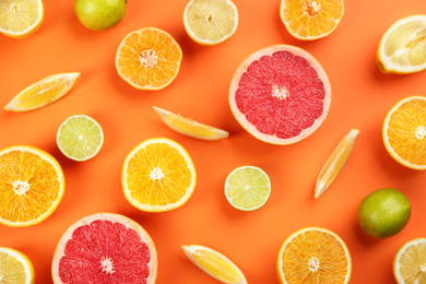 Flat lay composition with tangerines and different citrus fruits on orange background