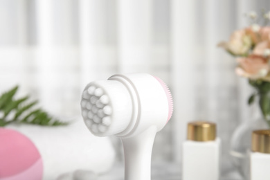Photo of Modern face cleansing brush on blurred background. Cosmetic accessory