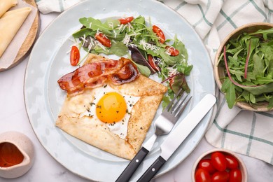 Delicious crepe with egg served on white marble table, flat lay. Breton galette