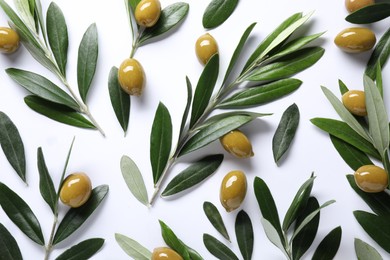 Photo of Fresh green olives and leaves on white background, flat lay