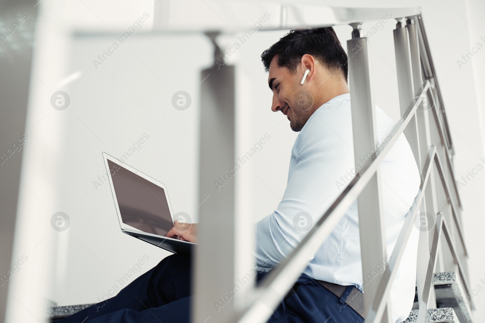 Photo of Portrait of young man with laptop indoors