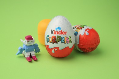 Sveti Vlas, Bulgaria - June 29, 2023: Kinder Surprise Eggs, plastic capsule and toy on light green background