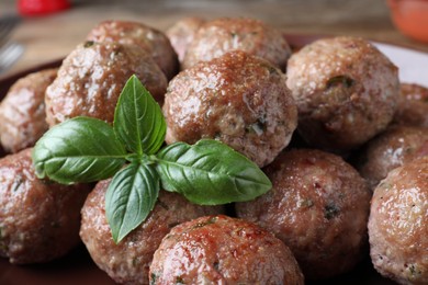 Tasty cooked meatballs and basil, closeup view