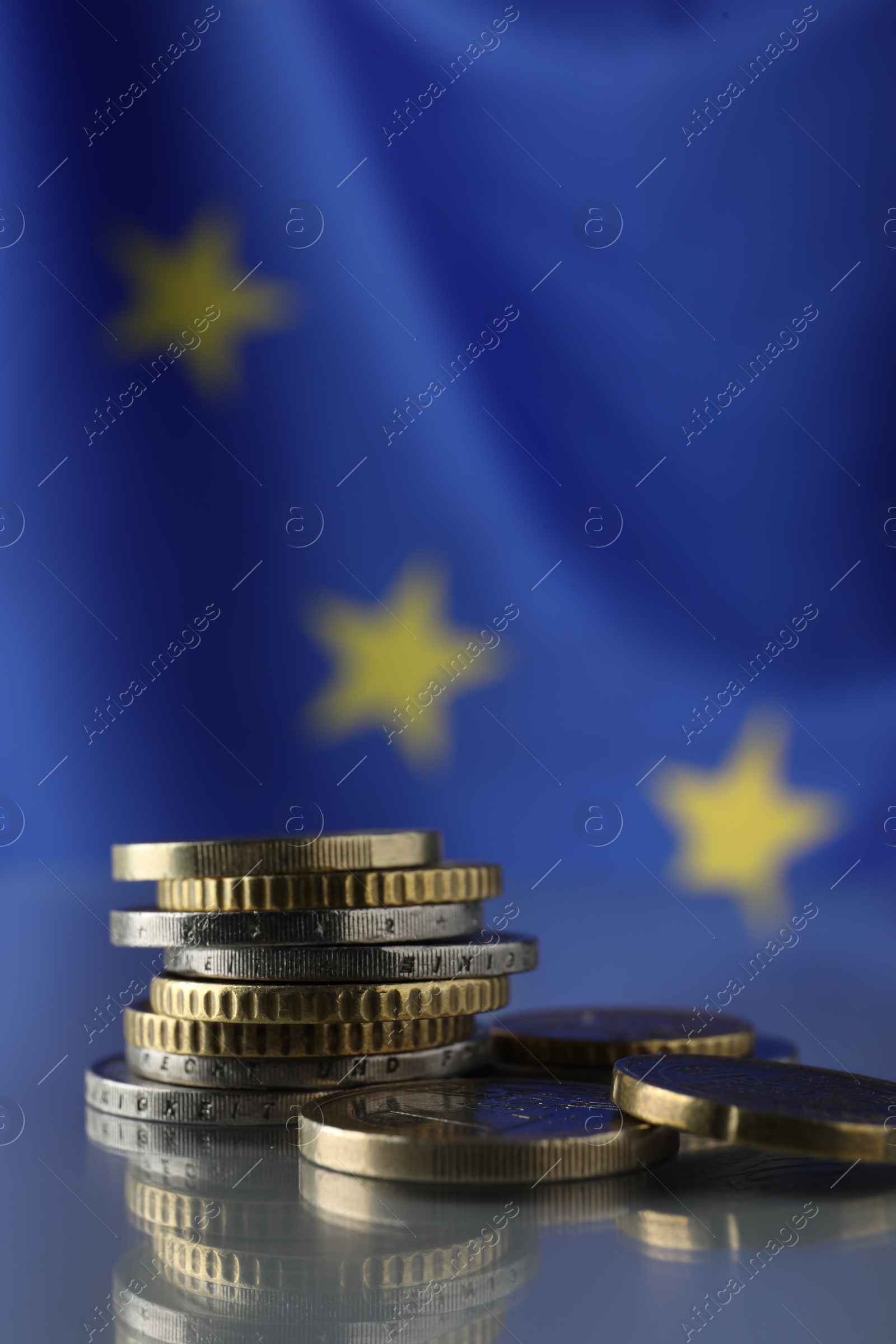 Photo of Coins on table against European Union flag, closeup. Space for text