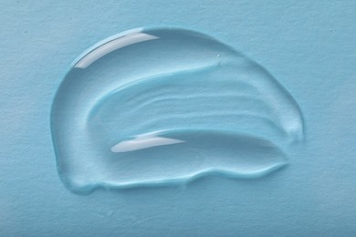 Photo of Smear of ointment on light blue background, top view