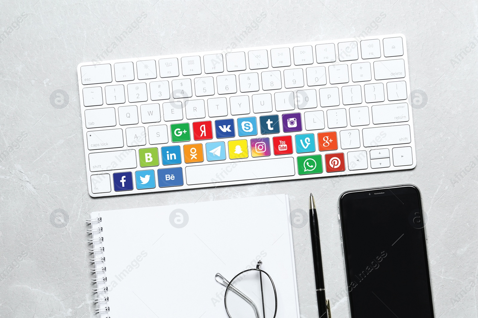 Image of MYKOLAIV, UKRAINE - APRIL 30, 2020: Computer keyboard with social media apps logotypes on marble table, flat lay