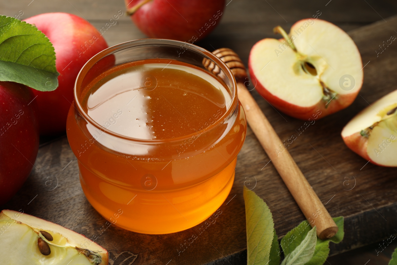 Photo of Sweet honey and fresh apples on wooden table, closeup