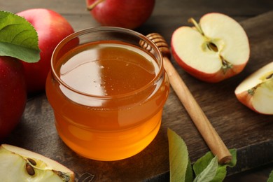 Sweet honey and fresh apples on wooden table, closeup