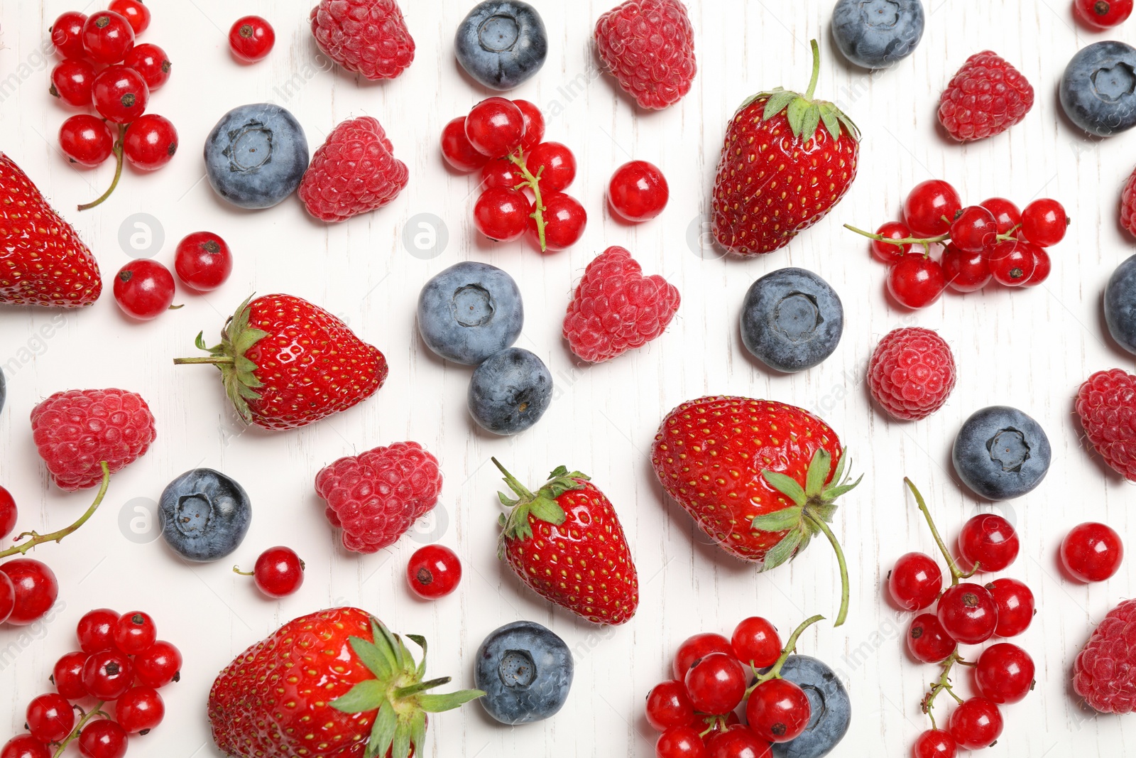 Photo of Different fresh berries on white wooden table, flat lay