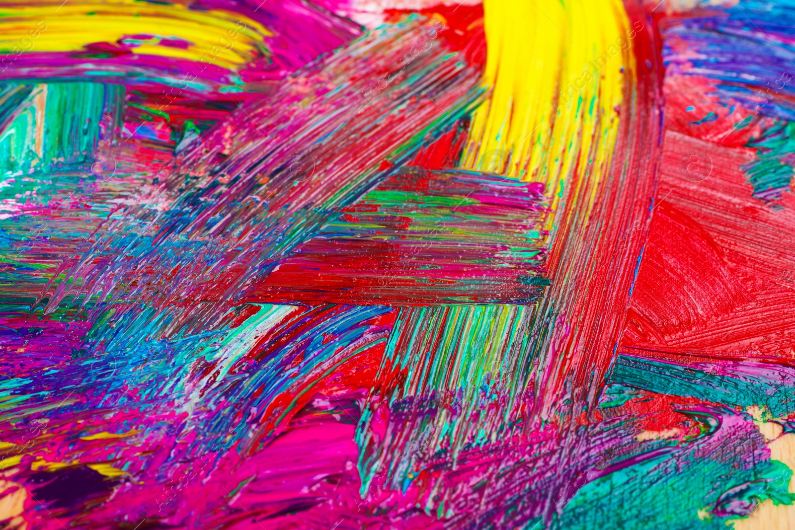 Photo of Closeup view of artist's palette with mixed bright paints as background