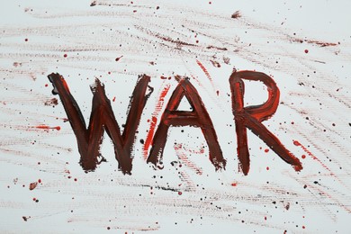 Word War written with black and red paint on white background, top view