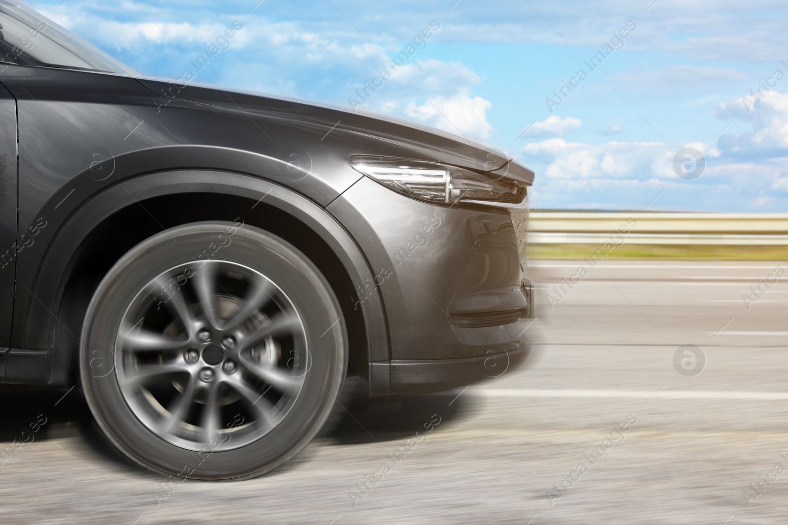 Image of Black car driving on road outdoors, motion blur effect. Space for text
