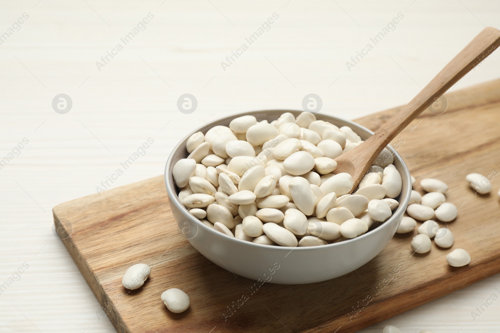 Photo of Raw beans on white wooden table, closeup