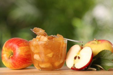 Delicious apple jam and fresh fruits on wooden table