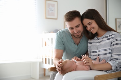 Photo of Happy couple with their newborn baby at home. Space for text