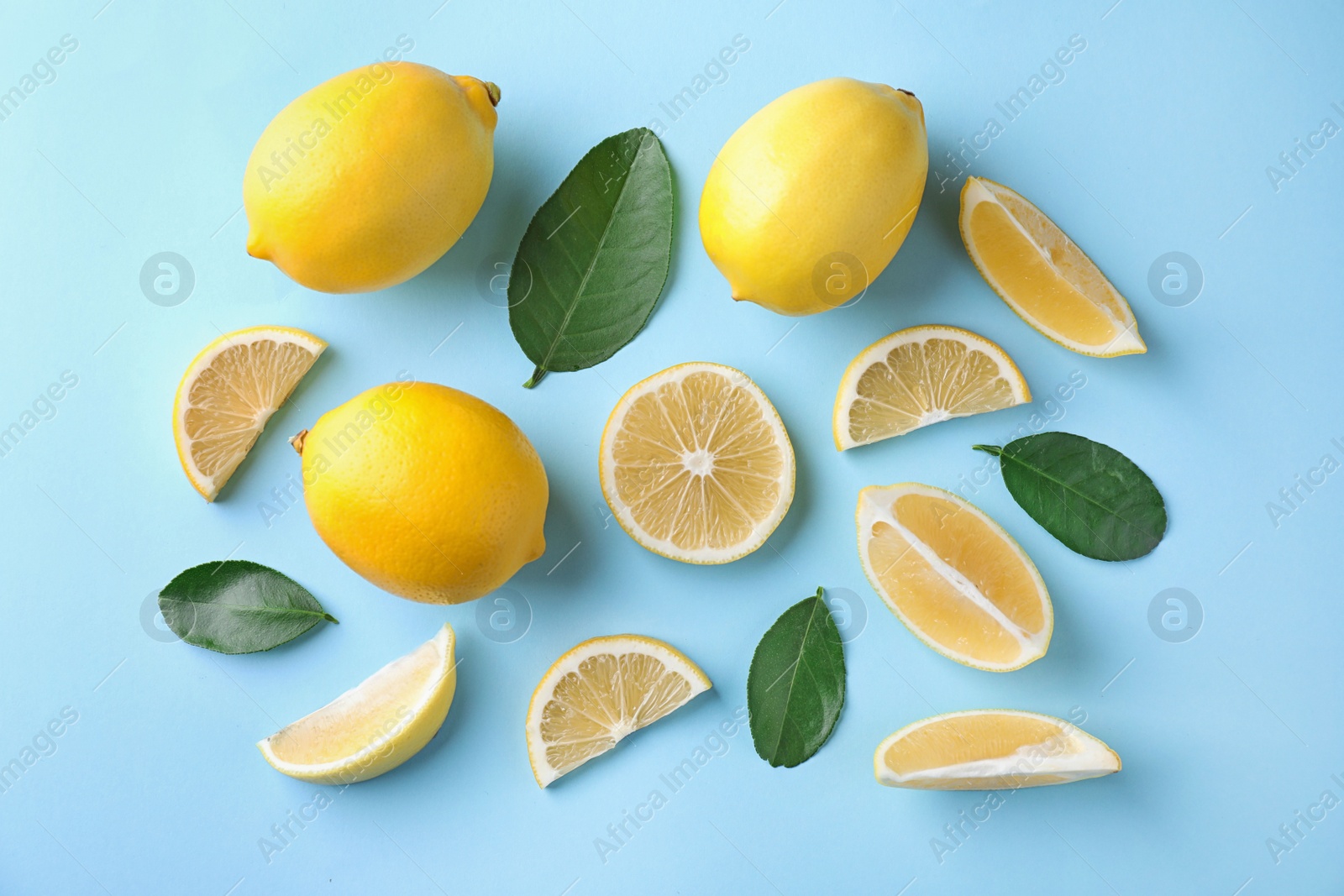 Photo of Flat lay composition with fresh lemons on light blue background