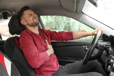 Photo of Mature man suffering from heart attack in car