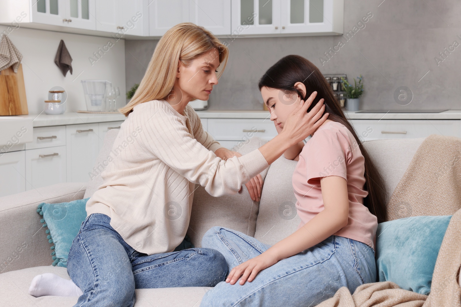 Photo of Mother consoling her upset daughter at home. Teenager problems
