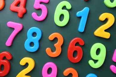 Photo of Colorful numbers on green background, flat lay