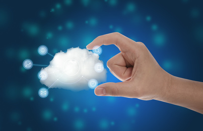 Image of Man holding cloud with icons on blue background, closeup. Modern technology