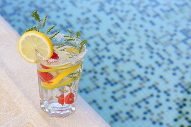 Photo of Delicious refreshing lemonade with raspberries near pool, space for text