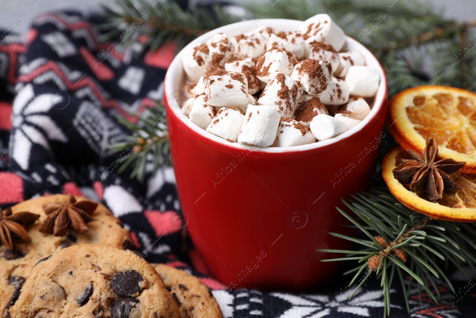 Photo of Cup of tasty cocoa with marshmallows on knitted cloth, closeup