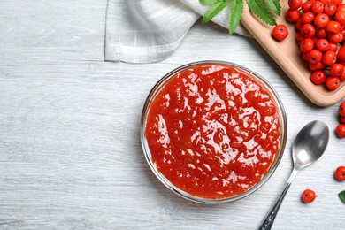 Flat lay composition with delicious rowan jam on white wooden table. Space for text