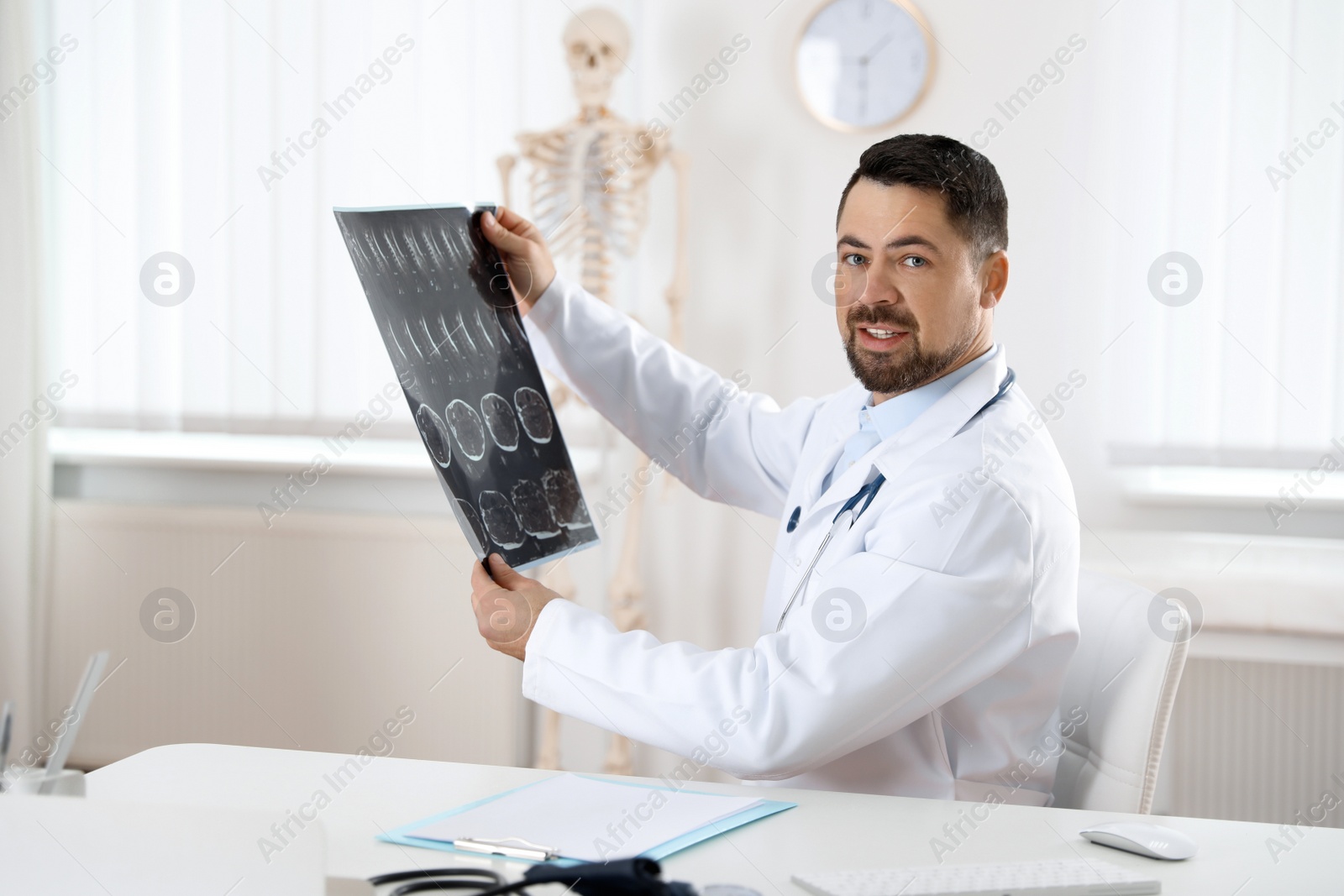 Photo of Orthopedist examining X-ray picture at desk in clinic