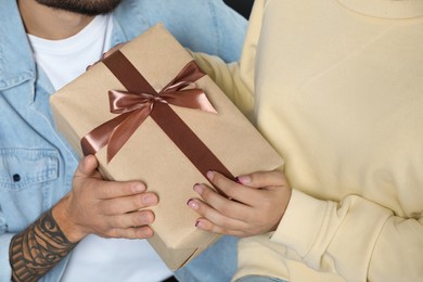 Photo of Lovely couple with beautiful gift, closeup view