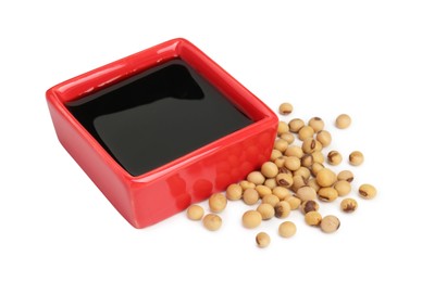 Photo of Tasty soy sauce in bowl and soybeans isolated on white