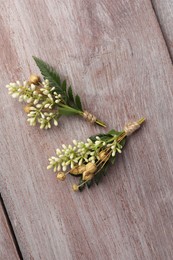 Photo of Small stylish boutonnieres on light wooden table, top view
