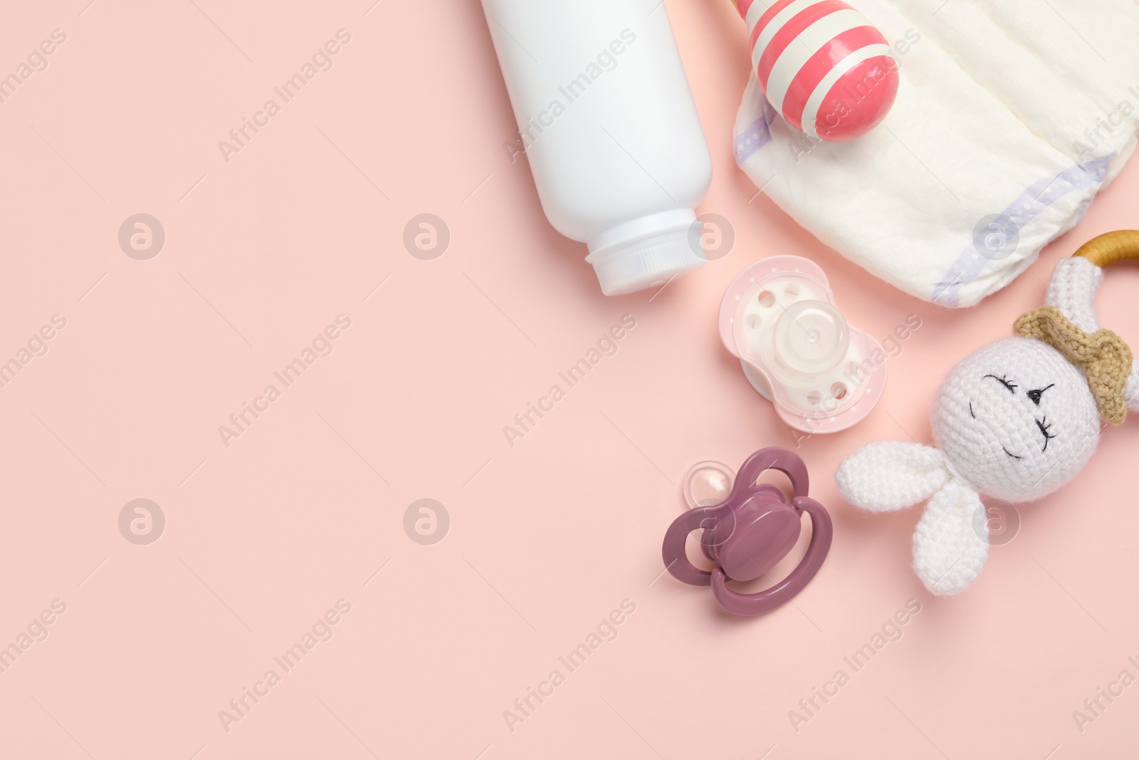 Photo of Flat lay composition with pacifiers and other baby stuff on pink background. Space for text