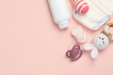 Photo of Flat lay composition with pacifiers and other baby stuff on pink background. Space for text