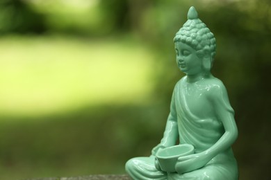 Decorative Buddha statue on blurred background, closeup. Space for text