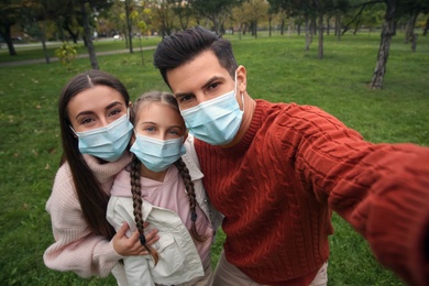 Photo of Lovely family taking selfie together in park during coronavirus pandemic