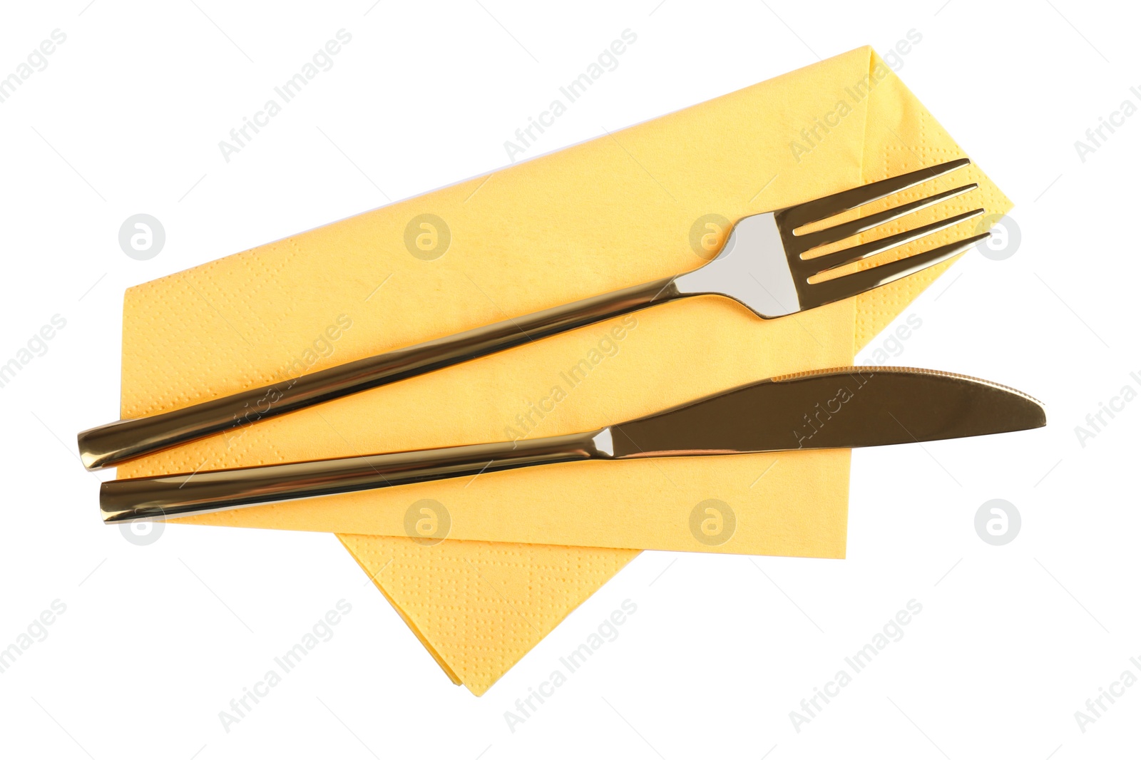 Photo of Yellow napkin with golden fork and knife on white background, top view