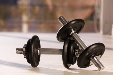 Photo of Pair of adjustable dumbbells on floor indoors