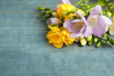 Photo of Beautiful fresh freesia flowers on color background, closeup. Space for text