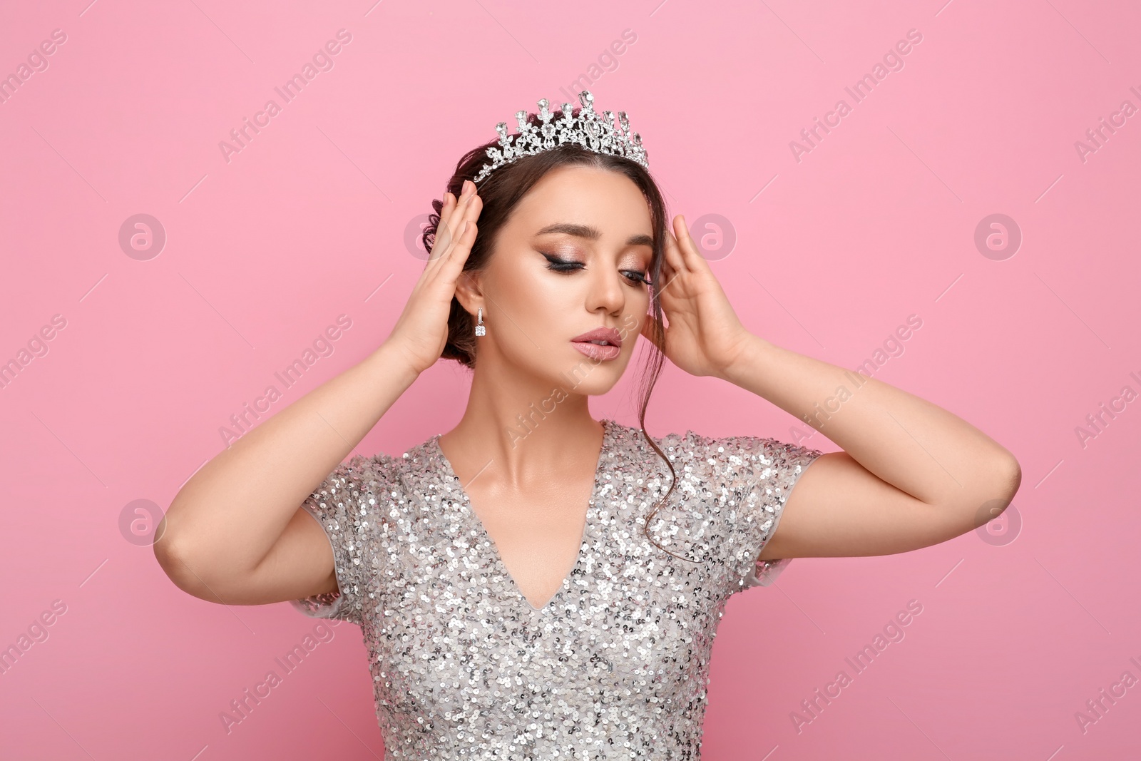 Photo of Beautiful young woman wearing luxurious tiara on pink background