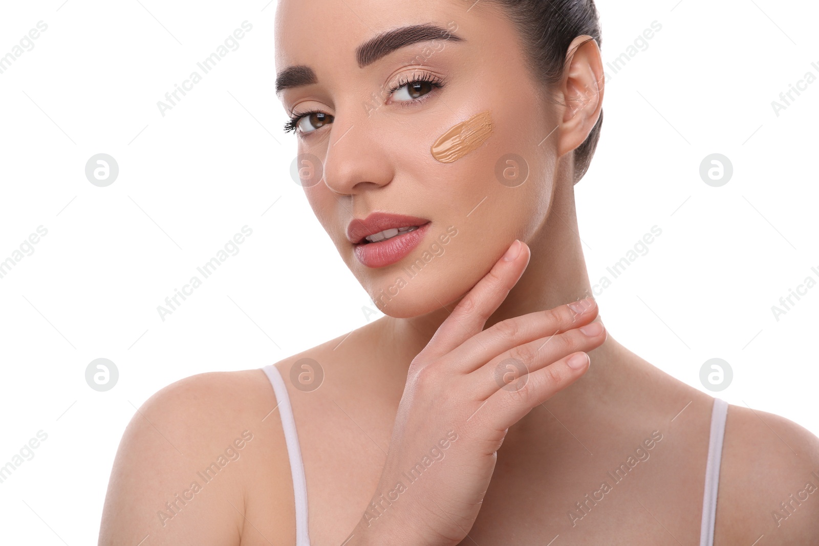 Photo of Woman with swatch of foundation on face against white background