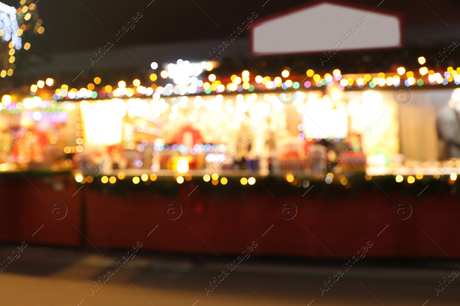 Photo of Blurred view of Christmas fair stalls outdoors at night