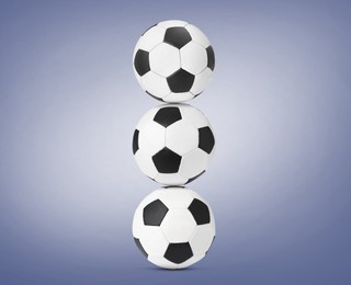 Image of Stack of soccer balls on pale blue background