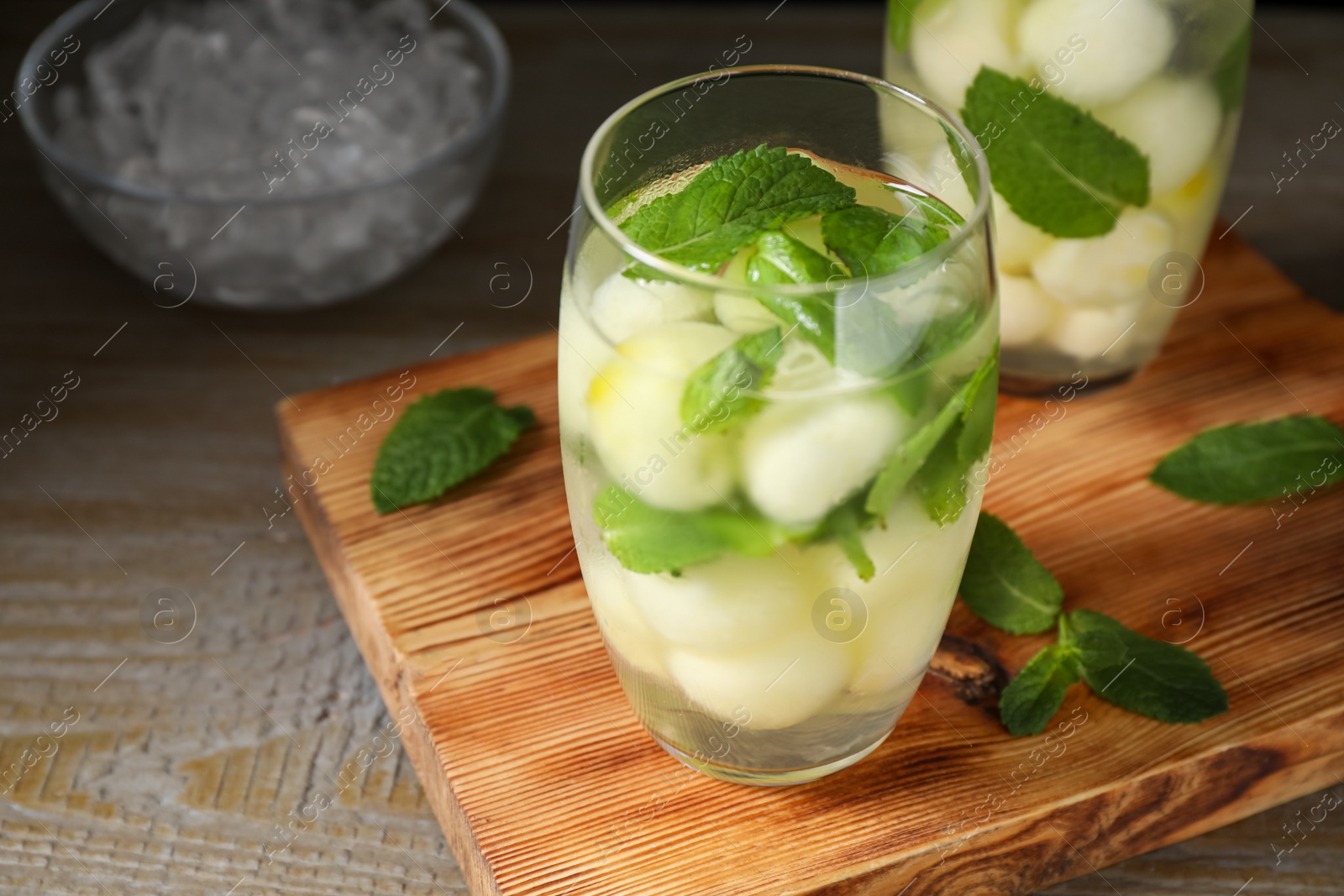 Photo of Tasty melon ball drink on wooden table, closeup